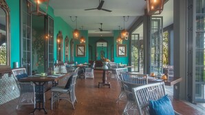 A spacious dining area with high ceilings, multiple tables, and chairs. - Kandy Dendrobium House (Puliyadda)