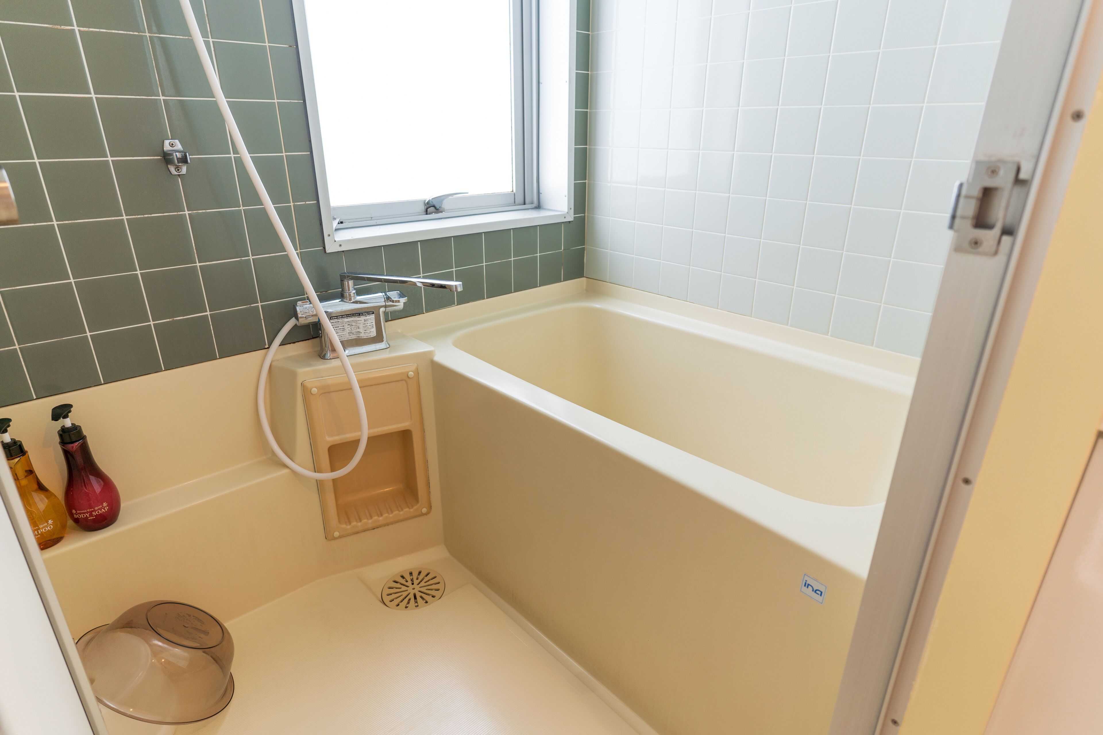 Un baño con bañera, ventana y ducha.