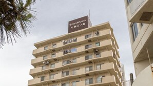 A multi-story building with balconies, a sign for 'Shonan Label Entertainment', and a white van parked in front. - kishu railway katase enoshima hotel (Fujisawa)