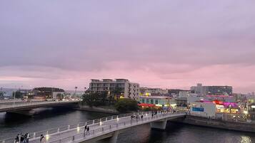 A bridge over water with buildings and a red-roofed structure in the background.