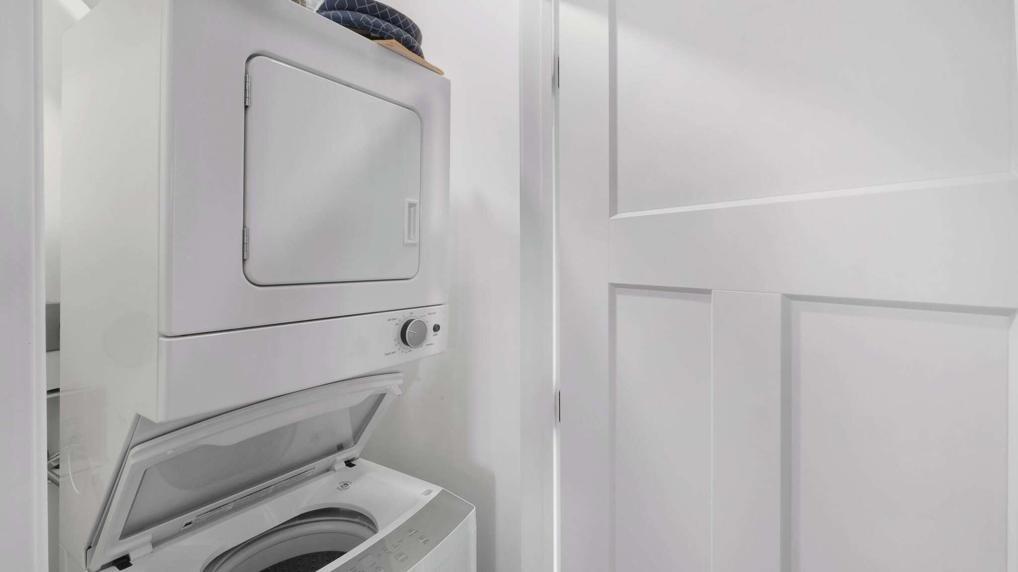 Een witte wasserij met een voorlader wasmachine en een droger.