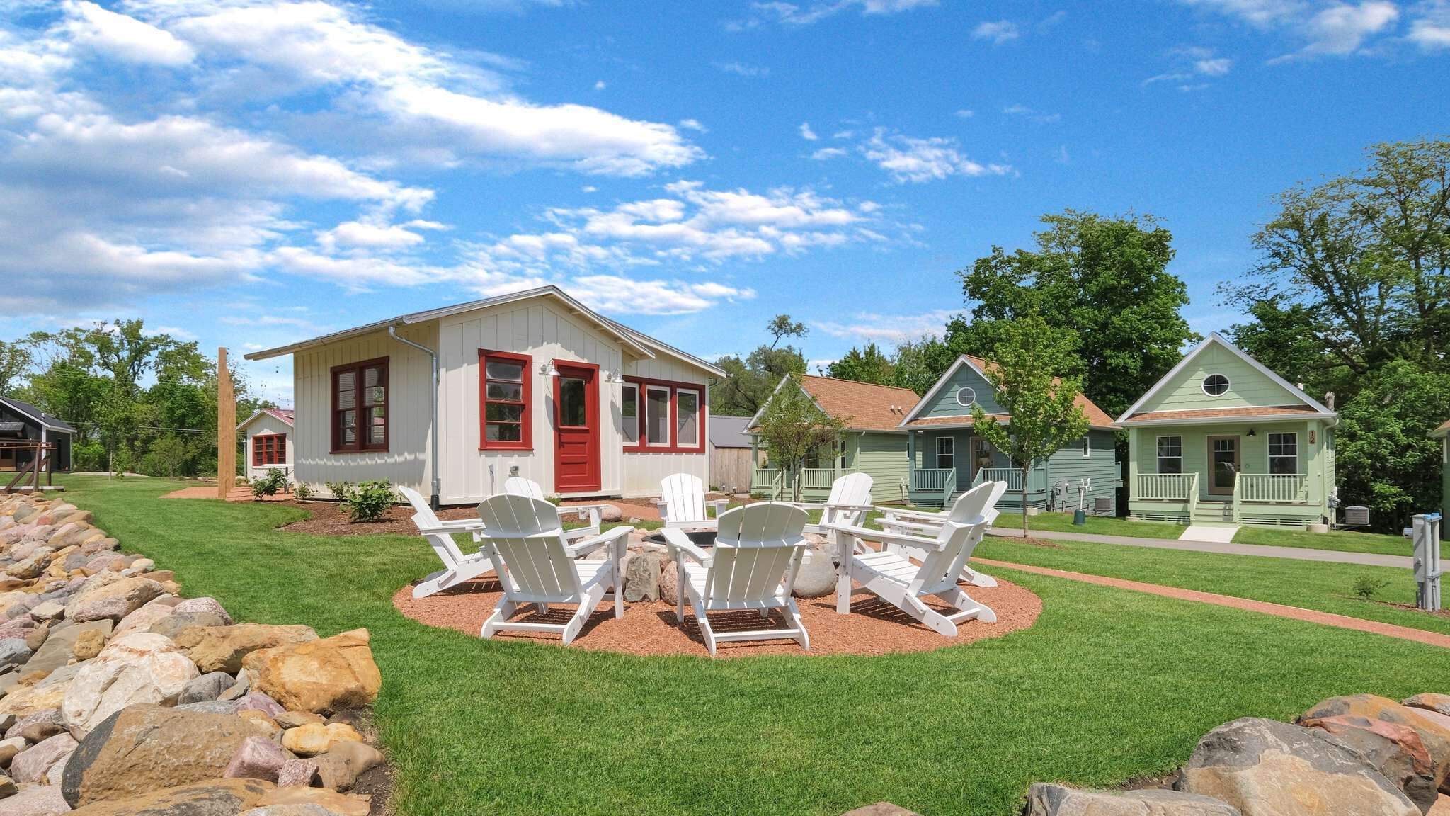A row of houses with a lawn and outdoor seating area.