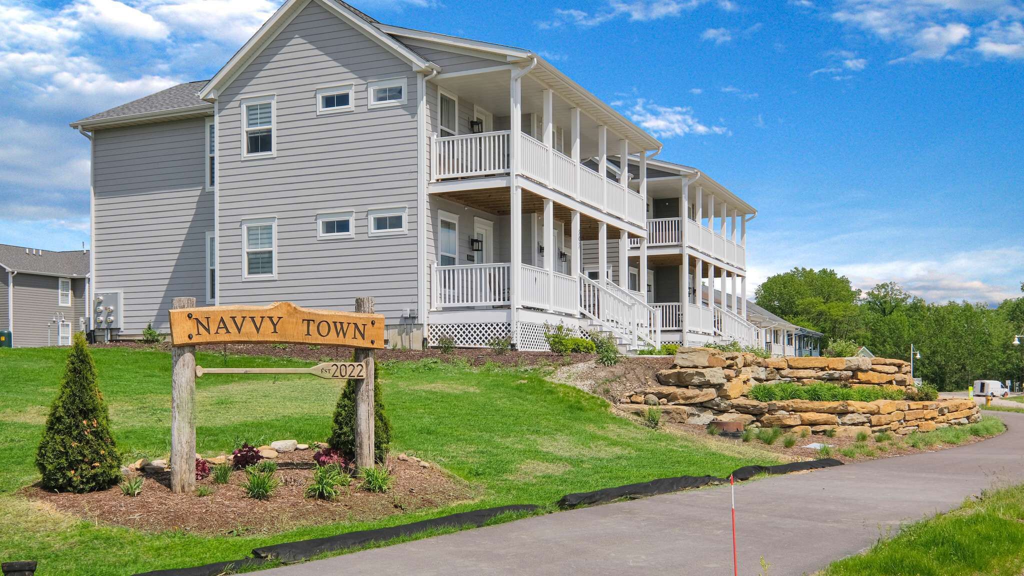 A two-story house with a porch and a sign that reads 'NAVY TOWN.'