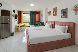 Relax in a spacious room with a large bed, separate seating area, and refrigerator.