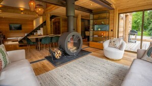 A modern interior with a fireplace, wooden furniture, and a dining area.