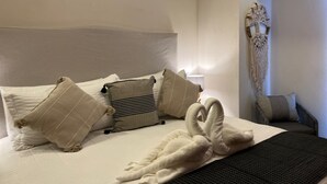A neatly made bed with a swan-shaped towel and several pillows. - Across the Street from the Ocean Life Bucerias 129 (Bucerías)