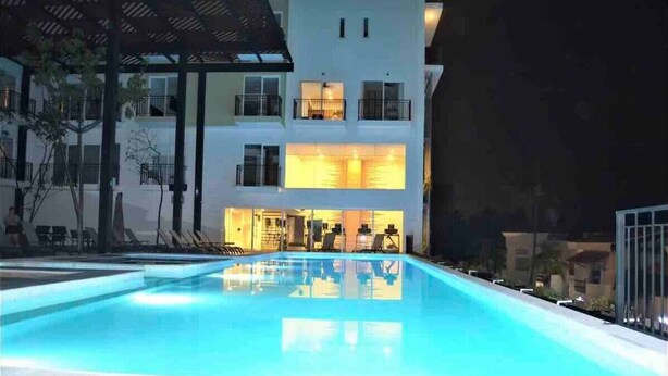 A swimming pool with a modern building in the background. - Across the Street from the Ocean Life Bucerias 129 (Bucerías)
