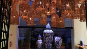 A display of blue and white vases on a glass table, with hanging woven light fixtures above. - Across the Street from the Ocean Life Bucerias 129 (Bucerías)