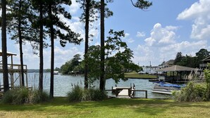 A lakeside property with a dock, grassy area, and a view of the water. - 
Centerport GetAway, Family size cabin. Near restaurants, golf and AU football (Dadeville)