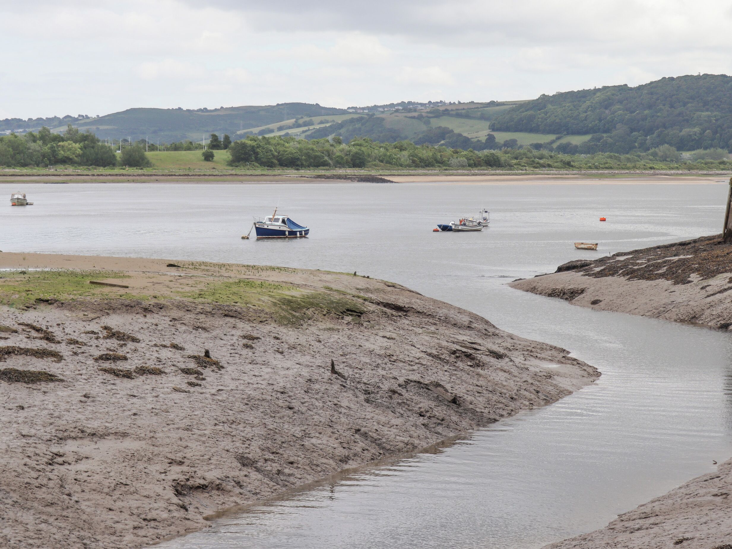 A river with boats and a sandy shore.