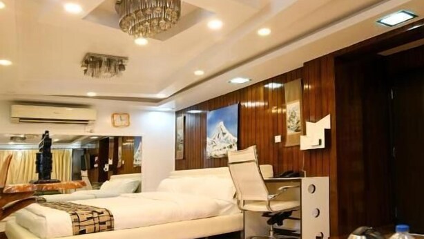 Una habitación de hotel moderna con una cama grande, un escritorio con una silla y una araña.