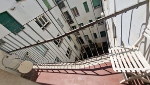 A spiral staircase with metal railings and a red-tiled landing area. - Nazionale 37 in Firenze (Florence)