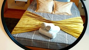 Ein Bett mit Kopfstück, Kissen und Decke.