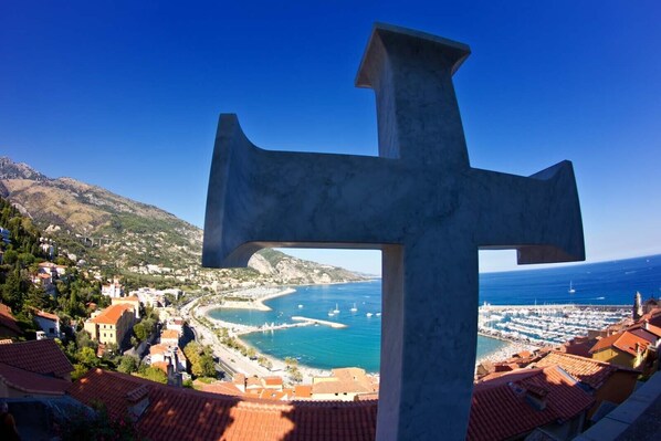 A large cross structure with a view of a coastal town and the sea. - Propa dla Czara (Benjamin)