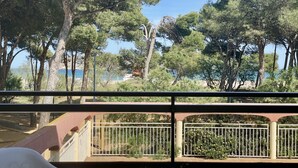 Ein Balkon mit Blick auf Bäume und ein Gewässer.