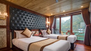 Une chambre d’hôtel avec deux lits, une grande fenêtre donnant sur un paysage montagneux et un plancher en bois.