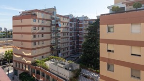 A multi-story residential building with balconies, a visible construction crane, and a clear sky. - Esperia Home penthouse in Bari with private terrace, Wi-Fi, and air conditioning (Bari)