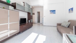 A modern living room with a sofa, TV, and cabinets. - Esperia Home penthouse in Bari with private terrace, Wi-Fi, and air conditioning (Bari)