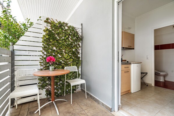 A small kitchen with white cabinets, a white refrigerator, and a white sink.