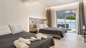 A hotel room with two beds, a desk, and a balcony with a pool view. - Studio 'King Room with Pool View' with Shared Pool, Wi-Fi and Air Conditioning (?e???da?)