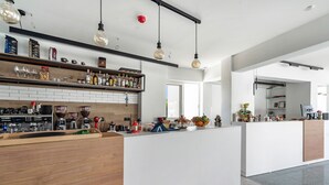A modern kitchen with a wooden countertop, coffee machines, and a variety of bottles. - Studio 'King Room with Pool View' with Shared Pool, Wi-Fi and Air Conditioning (?e???da?)