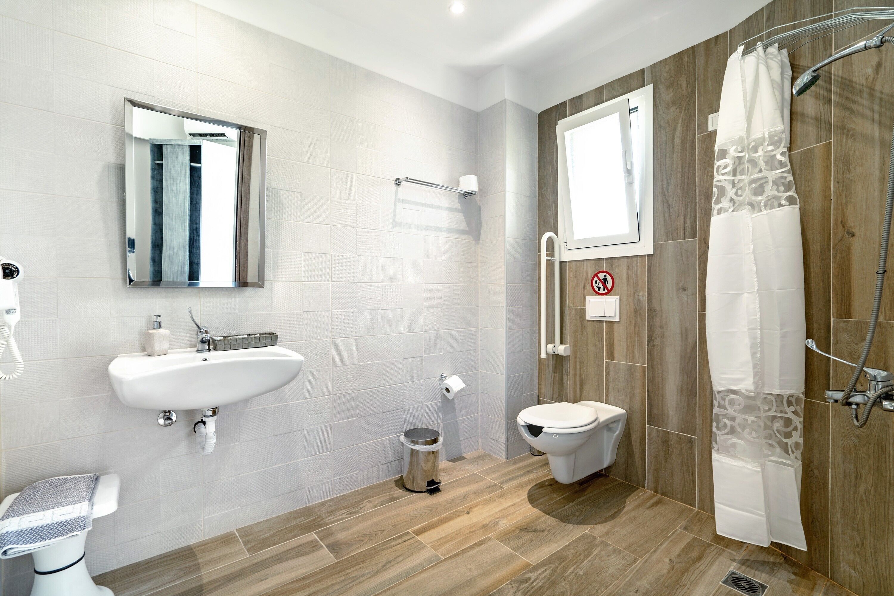 Ein modernes Badezimmer mit Waschbecken, Toilette, Dusche und Spiegel.