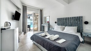 Ett modernt hotellrum med en säng, en platt-TV, ett skrivbord med en vattenkokare och utsikt mot omgivningen.
