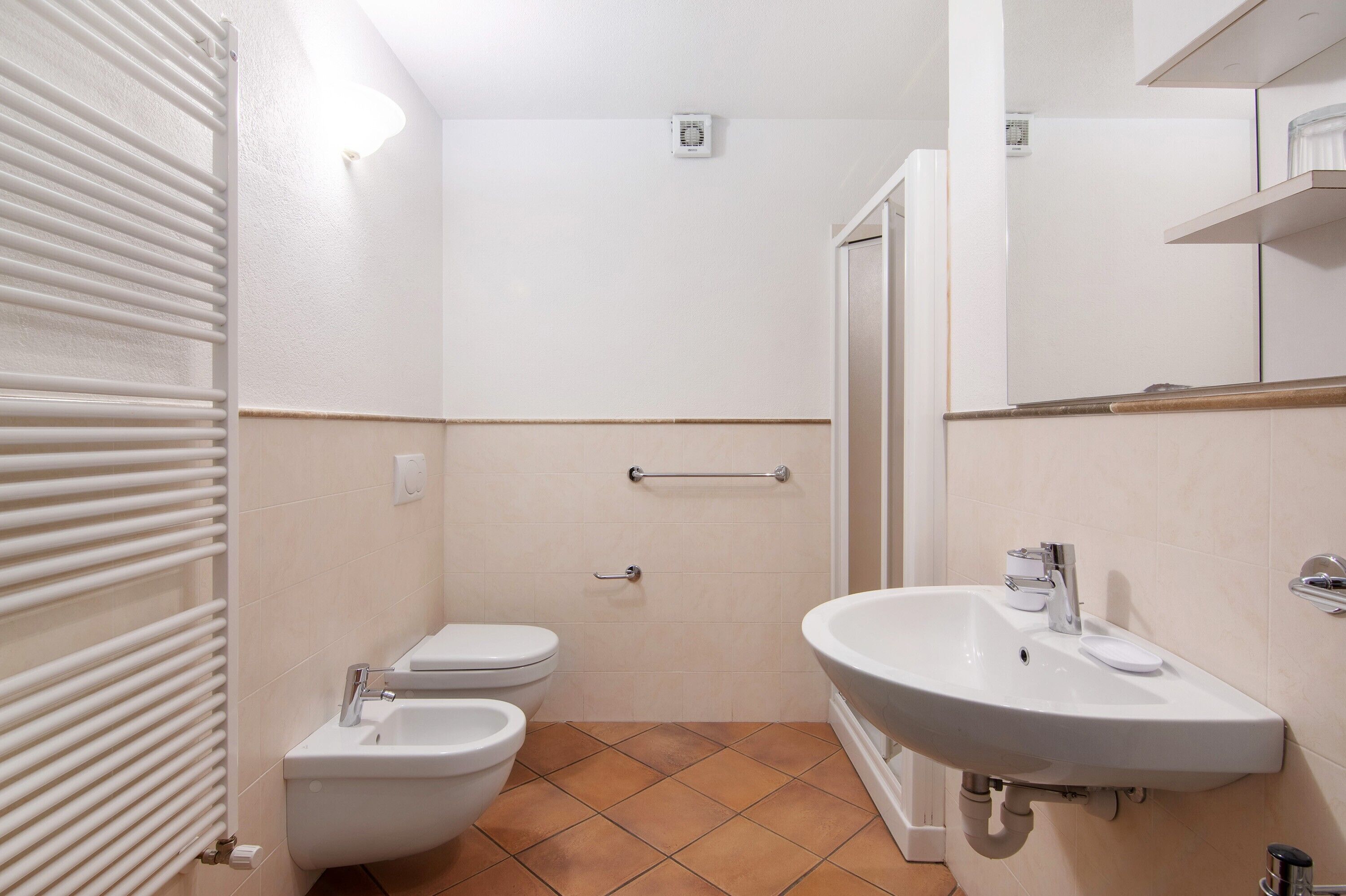 Et lille badeværelse med toilet, bidet og vask.