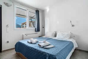 Une chambre à coucher avec un lit, une fenêtre donnant sur un beau paysage et une serviette sur le lit.