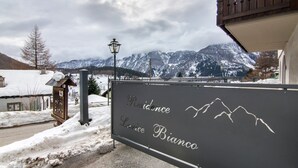 Ein Schild mit der Aufschrift 'Residence Lurice Bianco' und Blick auf die Berge.