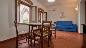 Ein Essbereich mit Tisch und Stühlen, einem blauen Sofa und einem Kamin.
