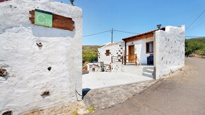 A white building with a wooden door and a small porch. - Rural Holiday Home 'Alto Prado' with Sea View, Private Terrace and Wi-Fi (Valverde)