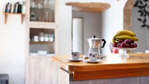 A wooden counter with a coffee maker, two cups, and a fruit display. - Rural Holiday Home 'Alto Prado' with Sea View, Private Terrace and Wi-Fi (Valverde)