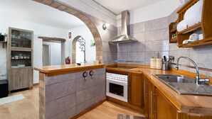 A kitchen with a central island, a built-in oven, a stainless steel sink, and a wooden cabinet. - Rural Holiday Home 'Alto Prado' with Sea View, Private Terrace and Wi-Fi (Valverde)