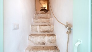 Eine Treppe mit einer an der Wand befestigten Leine, einem Lichtschalter und einer Steckdose.