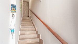 Un escalier avec des rampes en bois, un luminaire suspendu et une pancarte de bienvenue.