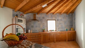 Una cocina con armarios de madera, un microondas y un ventanal.