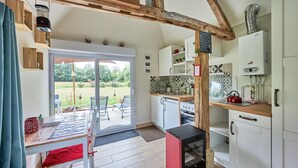 A kitchen with a sliding glass door to a garden, a built-in oven, and a water heater.