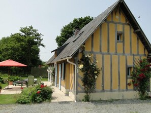 Ein traditionelles Fachwerkhäuschen mit geneigtem Dach, einem kleinen Fenster und einer Tür.