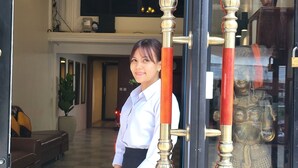 A woman standing in front of a glass door with ornate metal handles. - Sun Chakra Boutique Hotel (Phnom Penh)
