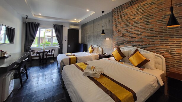 A hotel room with two beds, a desk, and a dining area. - Sun Chakra Boutique Hotel (Phnom Penh)