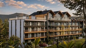 A multi-story hotel with balconies, large windows, and a mountainous backdrop. - Złoty Horyzont Resort Szklarska Poręba (Szklarska Poreba)