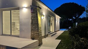 Uma casa moderna com fachada de pedra, grandes janelas e exterior bem iluminado.