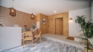 Un intérieur moderne avec un mur en bois, un bureau avec un ordinateur et un coin repas comprenant des chaises et une table.