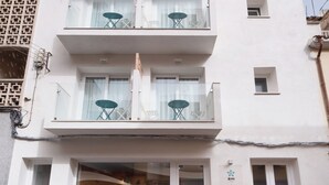 Un hôtel à plusieurs étages doté de balcons, d’une entrée avec une porte en verre et d’une enseigne bien visible indiquant qu’il s’agit d’un établissement proposant à la fois hébergement et petit-déjeuner.
