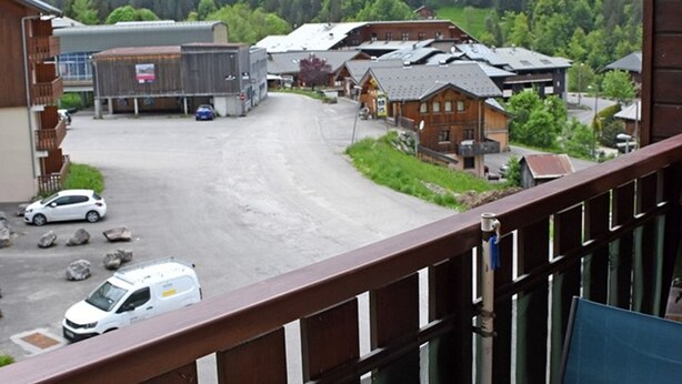 A view of a building with a parking lot and a forested mountain backdrop. - 22m² Studio in Saint-Jean-d'Aulps, near slopes (Saint-Jean-d'Aulps)