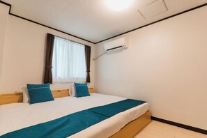 A bedroom with a bed, a window with curtains, an air conditioning unit, and a wooden headboard.