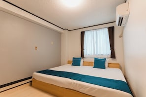 A bedroom with a bed, a window with curtains, and an air conditioning unit.