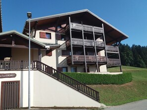 Um edifício de vários andares com varandas, uma escadaria e uma placa com a inscrição "Les Centaines".