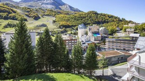 A mountainous town with modern buildings, a ski lift, and dense forest. - Studio cabin for 6 near ski slopes in Gourette, living room with balcony, parking (Gourette)